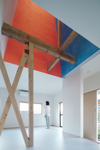 Interior view of the colourful ceiling and wooden beams at the Suzu apartment building renovation