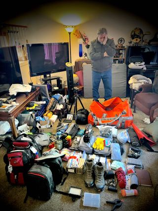Rod Pyle looks at all of his gear spread out on the ground around him as he packs for a simulated Mars mission in the Arctic.