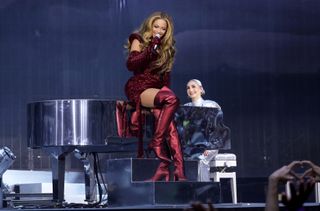 Beyonce sitting on a piano while performing