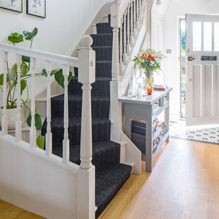 white hallway with staircase and grey runner