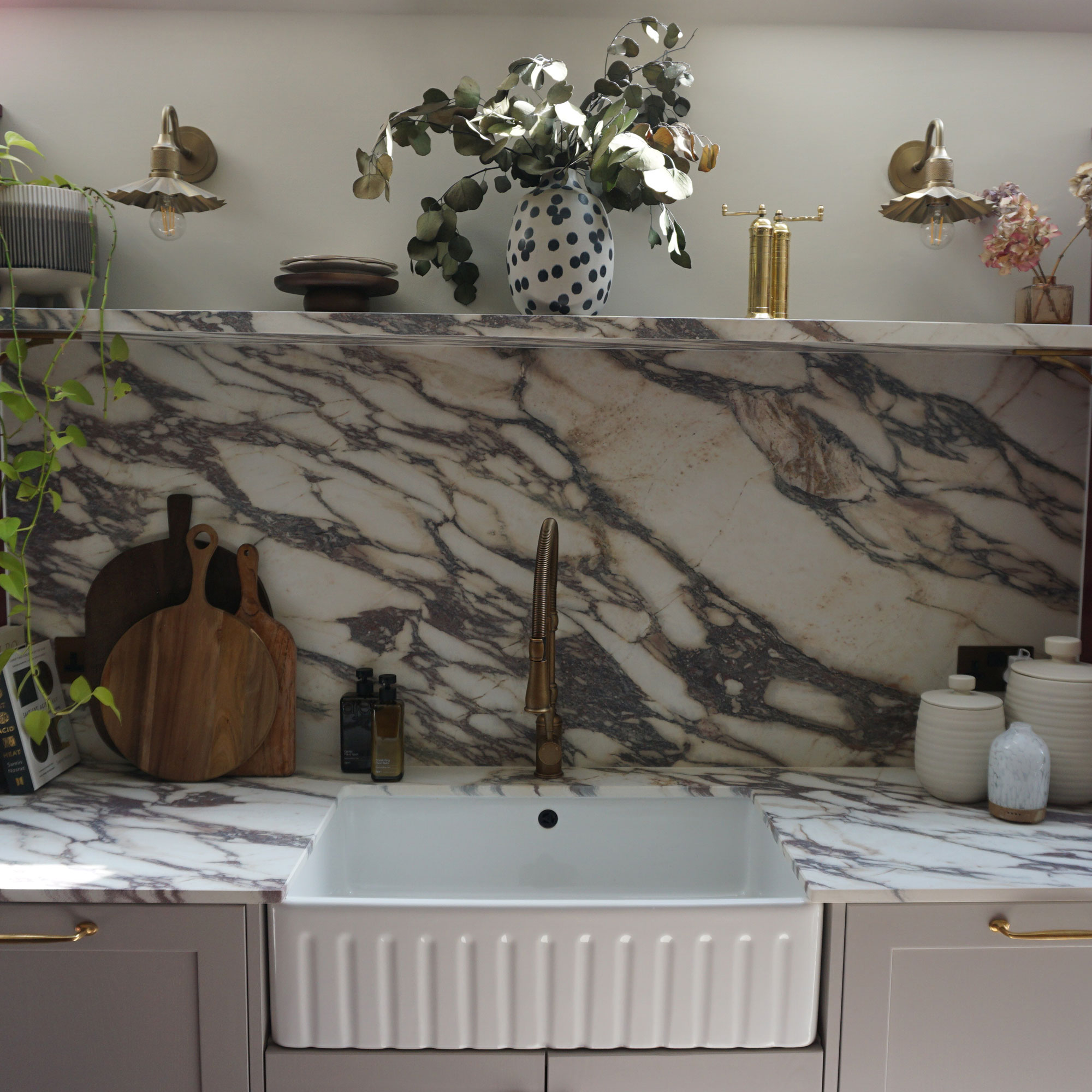 Fluted Belfast sink with brass tap on mable worktop and with marble splashback