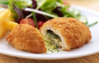 Chicken Kiev alongside salad on a plate