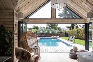 Pool house with swinging chair and view over the pool