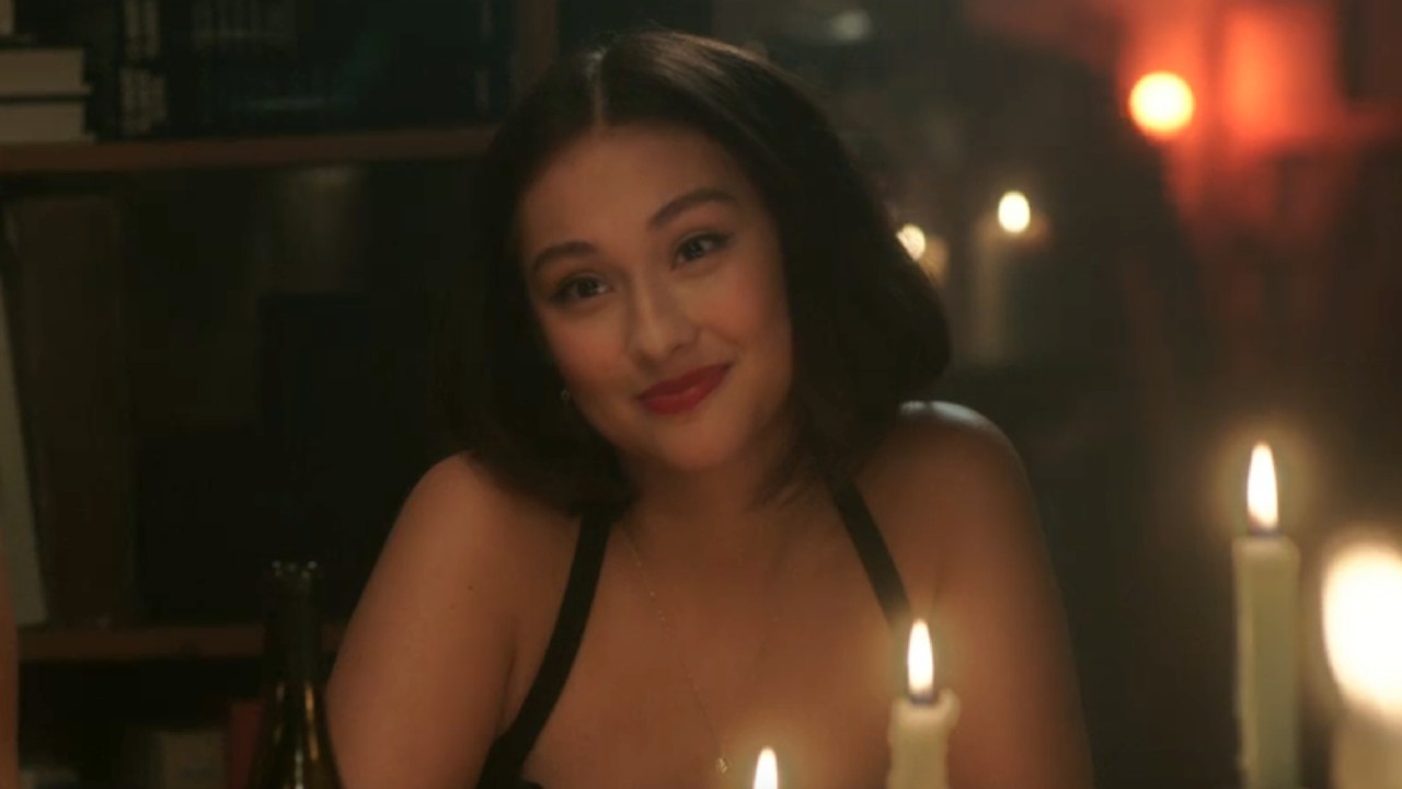 Belly looking forward with candels glowing in front of her and behind her.