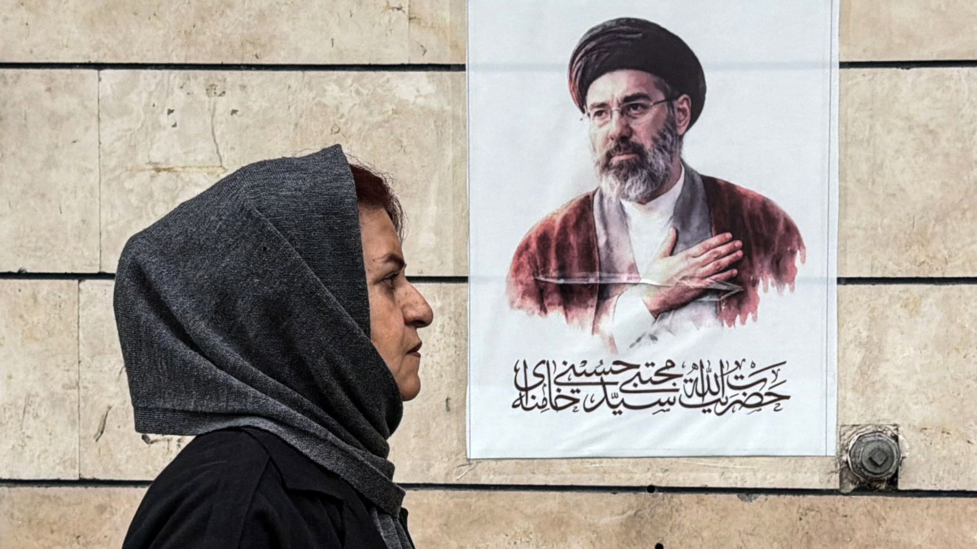 A woman walks past a portrait of Iran's Supreme Leader, Mojtaba Khamenei, in Tehran, following the failure of US-Iran peace talks in Pakistan