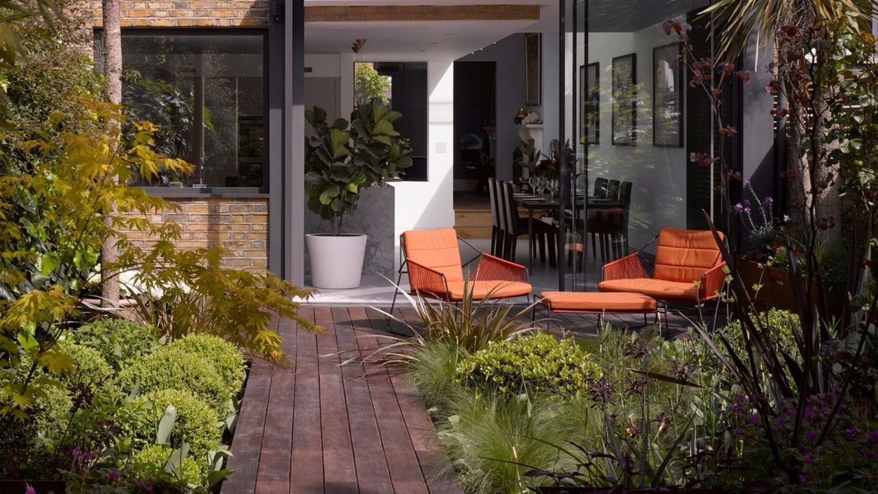 A tropical backyard with bright orange furniture