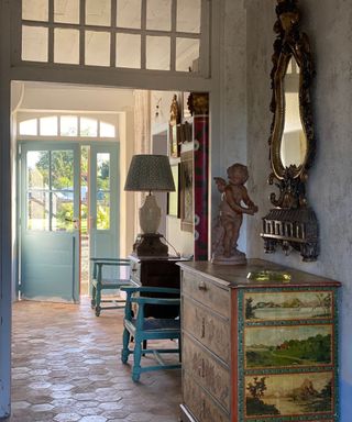 French country style entryway with antique furniture and reclaimed floor tiles