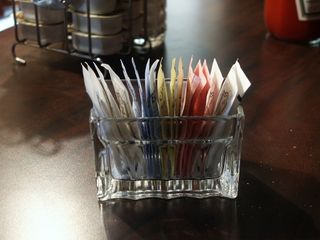 Packets of sweeteners sit on a table.