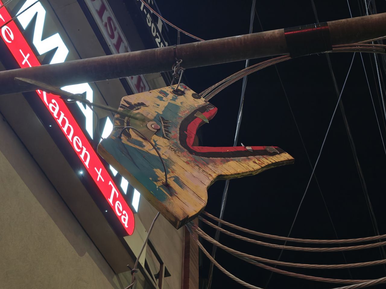 A carved wooden animal face hanging from a pole