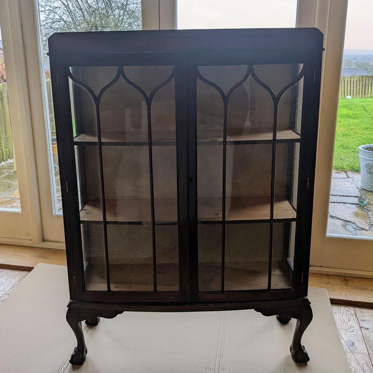Empty ornate wooden glass fronted cabinet