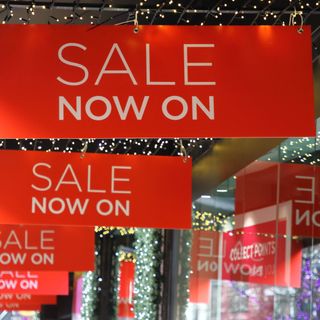 The outside of a John Lewis store decorated with Christmas lights and with red sale signs