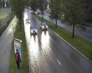 Tatu Gustafsson standing behind a sign next to a road