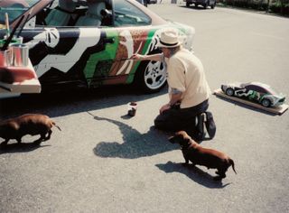 David Hockney painting BMW Art Car #14, BMW 850 CSi, 1995, dachsunds at his side