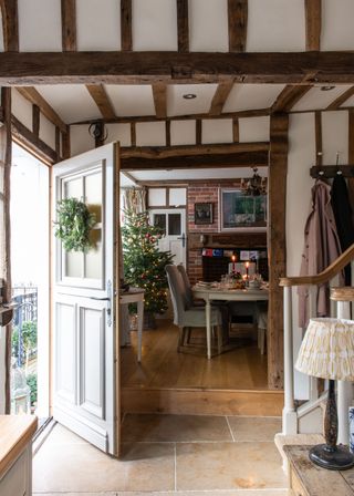 open door in a period home with beams and wreath and christmas tree