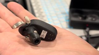 The Naqi Neural Earbuds held in a hand at CES 2024