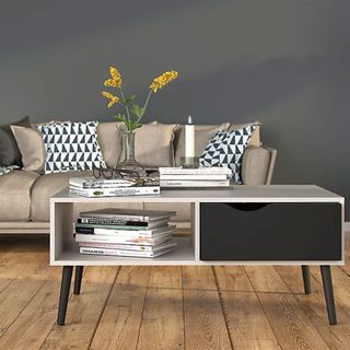 Ebru White & black Painted 1 Drawer Coffee table in front of a beige sofa in a grey living room with wooden floors