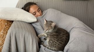 A woman having a nap with her cat