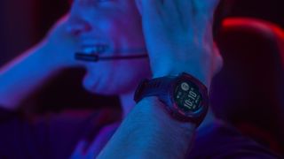 Man wearing gaming headset and Garmin Instinct Esports Edition smartwatch