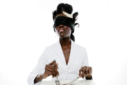 Blindfolded woman eating 