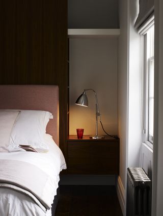 bedroom with alcove and fitted side table, lamp and shelf