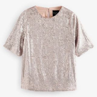 Cutout of a light gold sequin t-shirt on a light background