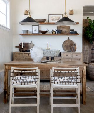 Rustic kitchen in wood with two woven chairs, contemporary accessories, and large, stone basin