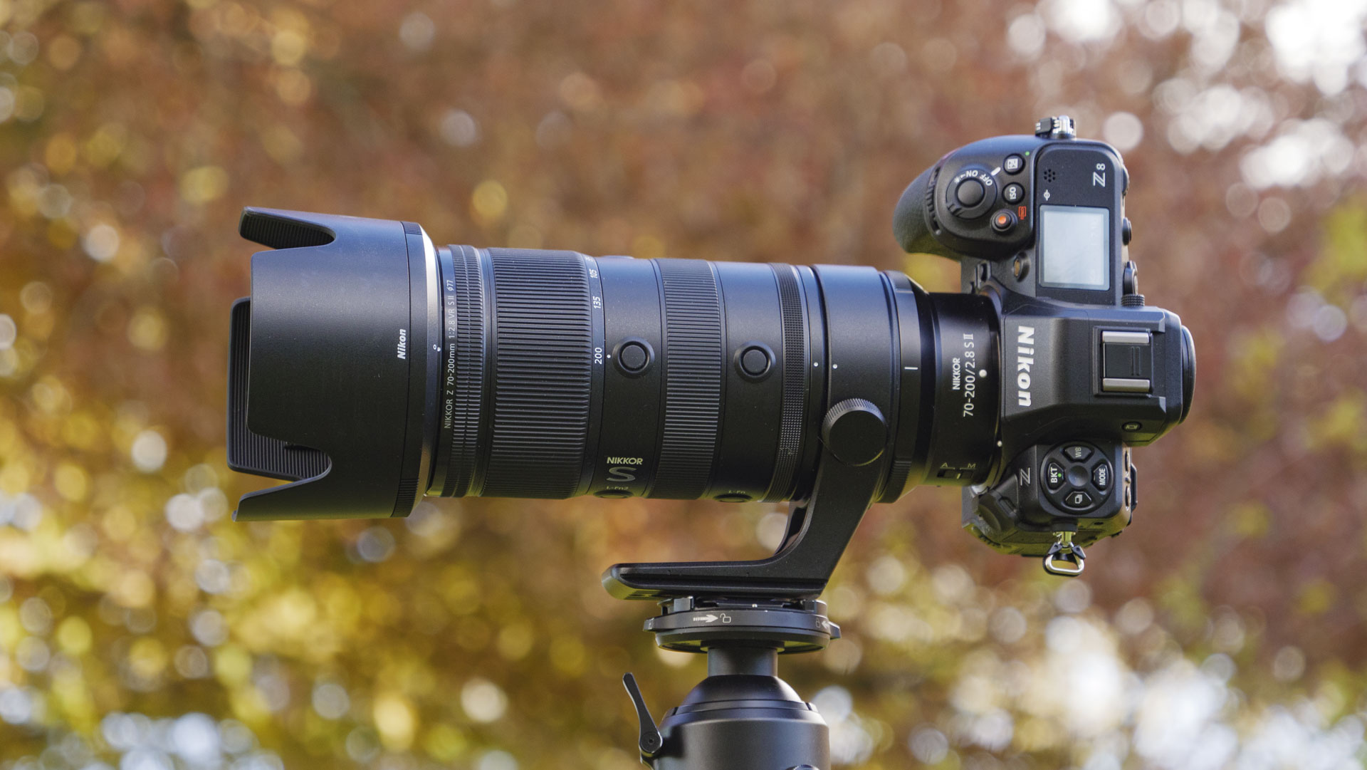 The Nikon Z 70-200mm f/2.8 VR S II lens attached to a Nikon Z8, the camera is mounted to a tripod and there are trees in the background
