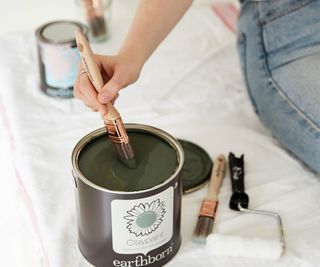 paintbrush in tin of green Earthborn paint