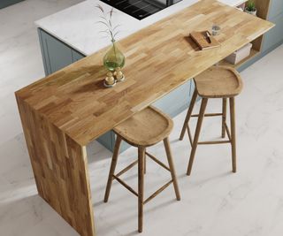 wooden breakfast bar sitting across the end of pale blue kitchen unit