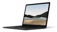 Surface Laptop 4 lightweight laptop shown in black colorway on white background with screen open at 95 degrees and showing a screensaver image of a desert plain and sand dunes, location unknown