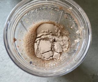 A scoop of protein powder in the blending bottle of the Nutribullet Portable Blender