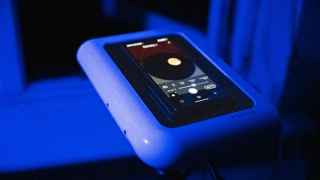 Vaonis Hestia smart telescope on a tripod pointing up at the night sky with a Google Pixel phone attached