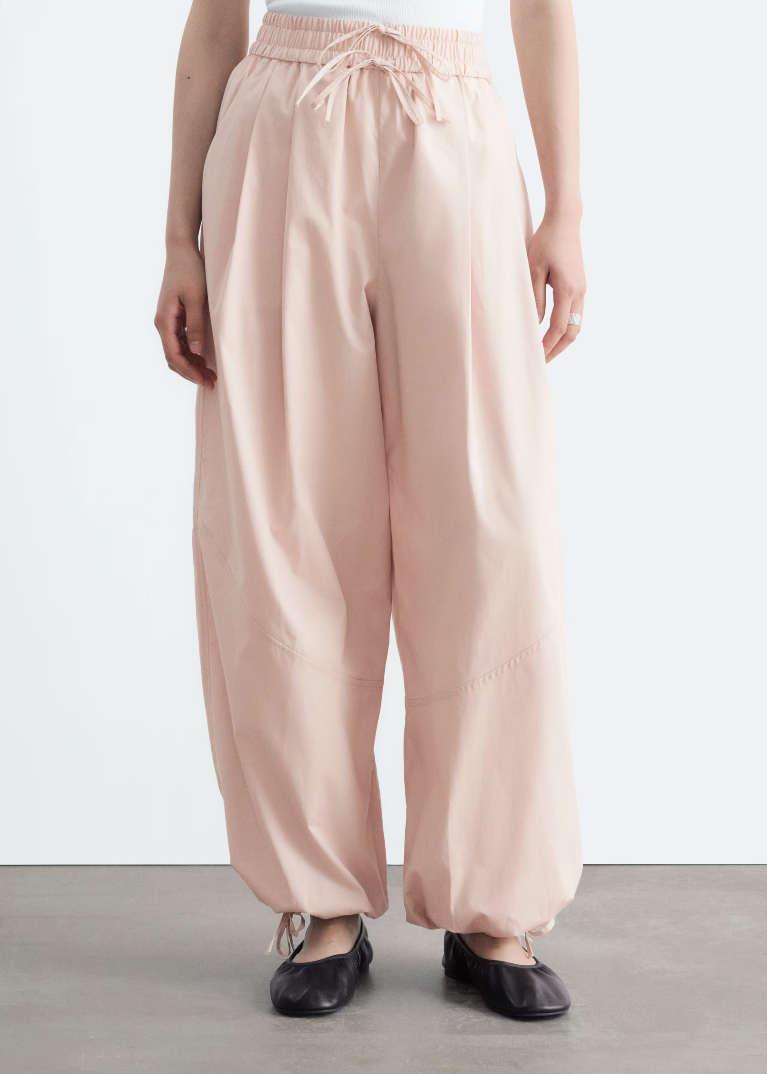 A model wears a pair of pink &amp;amp; Other Stories balloon trousers.