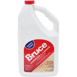 A white plastic jug with a handle built in. A red lid and sticker with Bruce branding. 