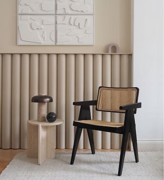 beige curved wall panelling with black chair