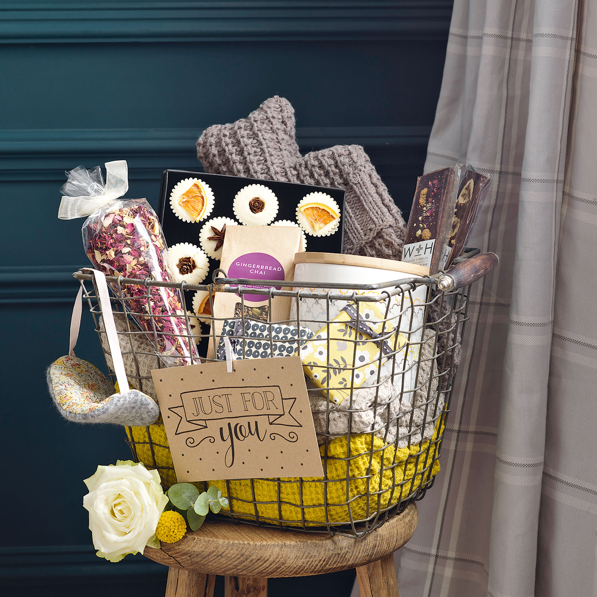 Metal basket with blankets, candles, soap, eye mask and hot water bottle