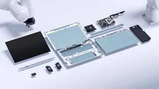 A disassembled laptop computer against a white background with a robot arm in the background