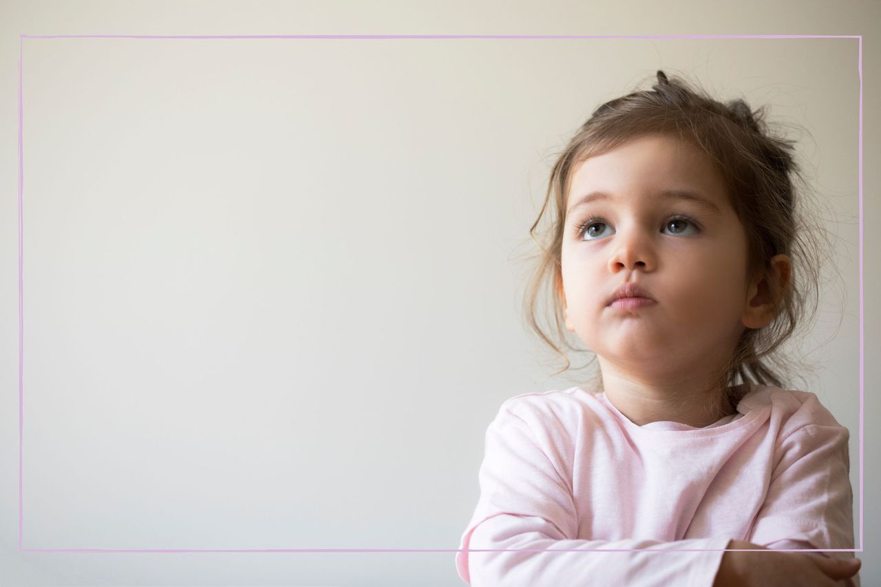 Serious looking toddler with her arms crossed