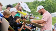 Jon Rahm of Spain signs his autograph for a fan during a practice round prior to the 2024 PGA Championship at Valhalla Golf Club on May 13, 2024 in Louisville, Kentucky.