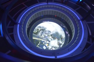 The "Stellarvator," a space elevator that brings guests to and from the Space 220 restaurant on the space station Centauri, is equipped with viewports showing the what is above and below -- the latter pictured, showing Walt Disney World's Epcot Center receding from view.