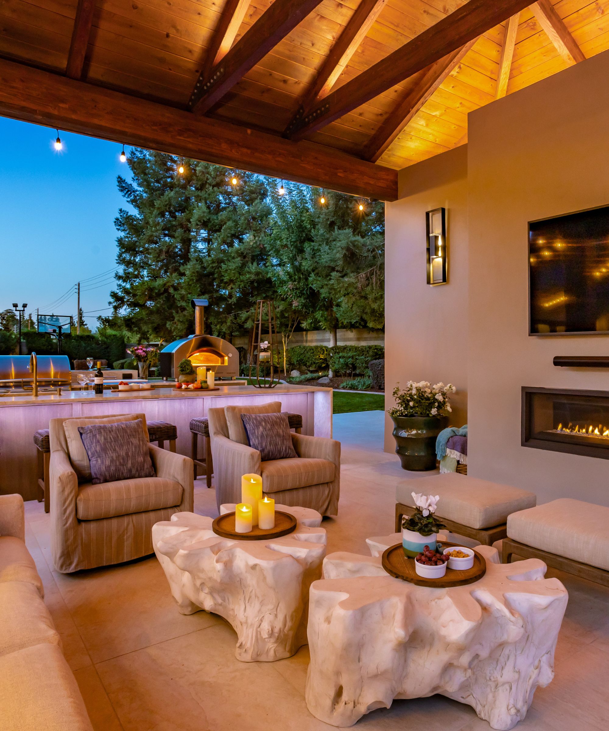 Outdoor covered living area with low tables, candles and soft seating