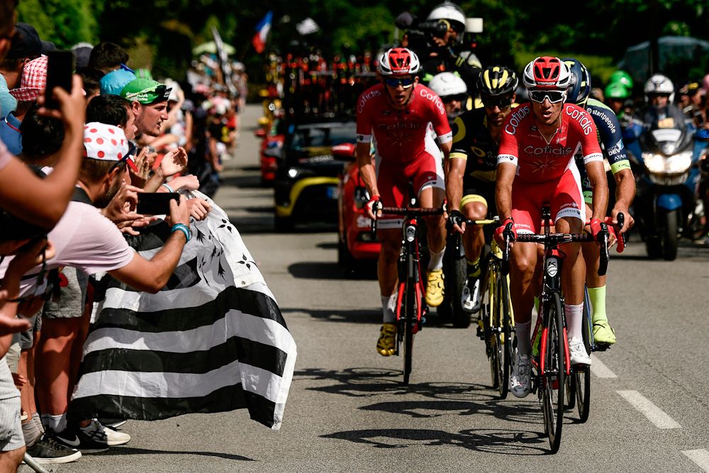 The breakaway passes a spectator with a Brittany flag during stage 4 at the Tour de France