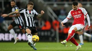 Arsenal's Gabriel Martinelli passes a ball past Newcastle United's Kieran Trippier in a Premier League game in November 2023.