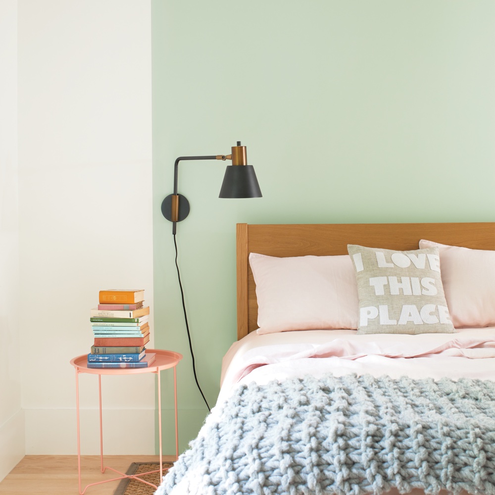 bedroom with bedside table and books and wooden floor