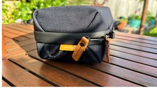 A closed VEO City Bag Technical Pack sitting on a wooden garden table