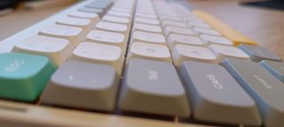 A white NuPhy Air75 V2 keyboard on a wooden desk