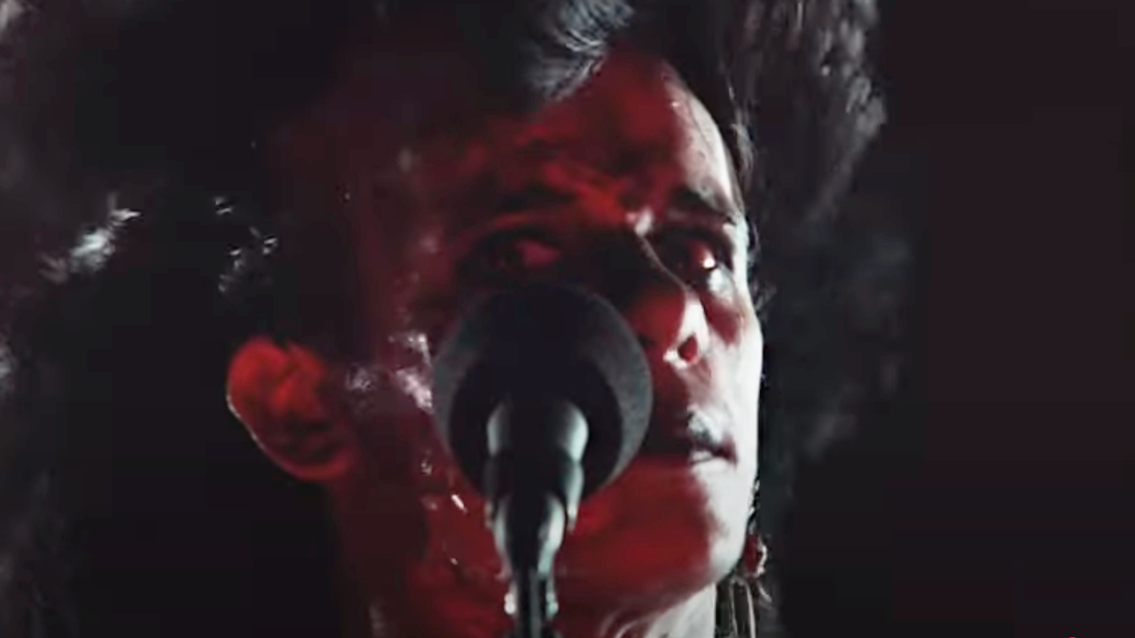 Tony Fields as Sammi Curr in front of a microphone in Trick or Treat