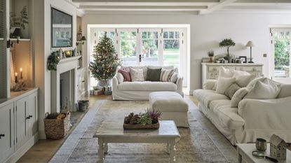 living room with white sofa and christmas tree