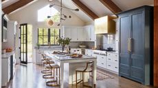 white kitchen with vaulted ceiling and double height blue larder unit