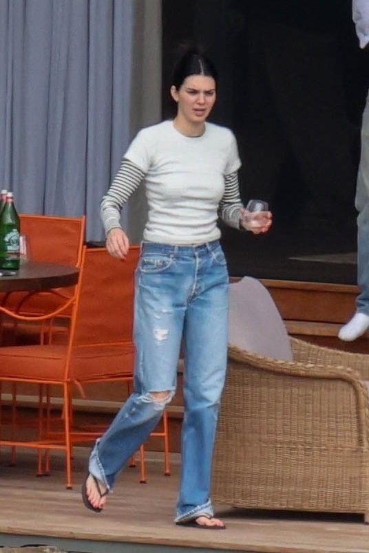 Kendall Jenner wears ripped jeans with flip-flops.